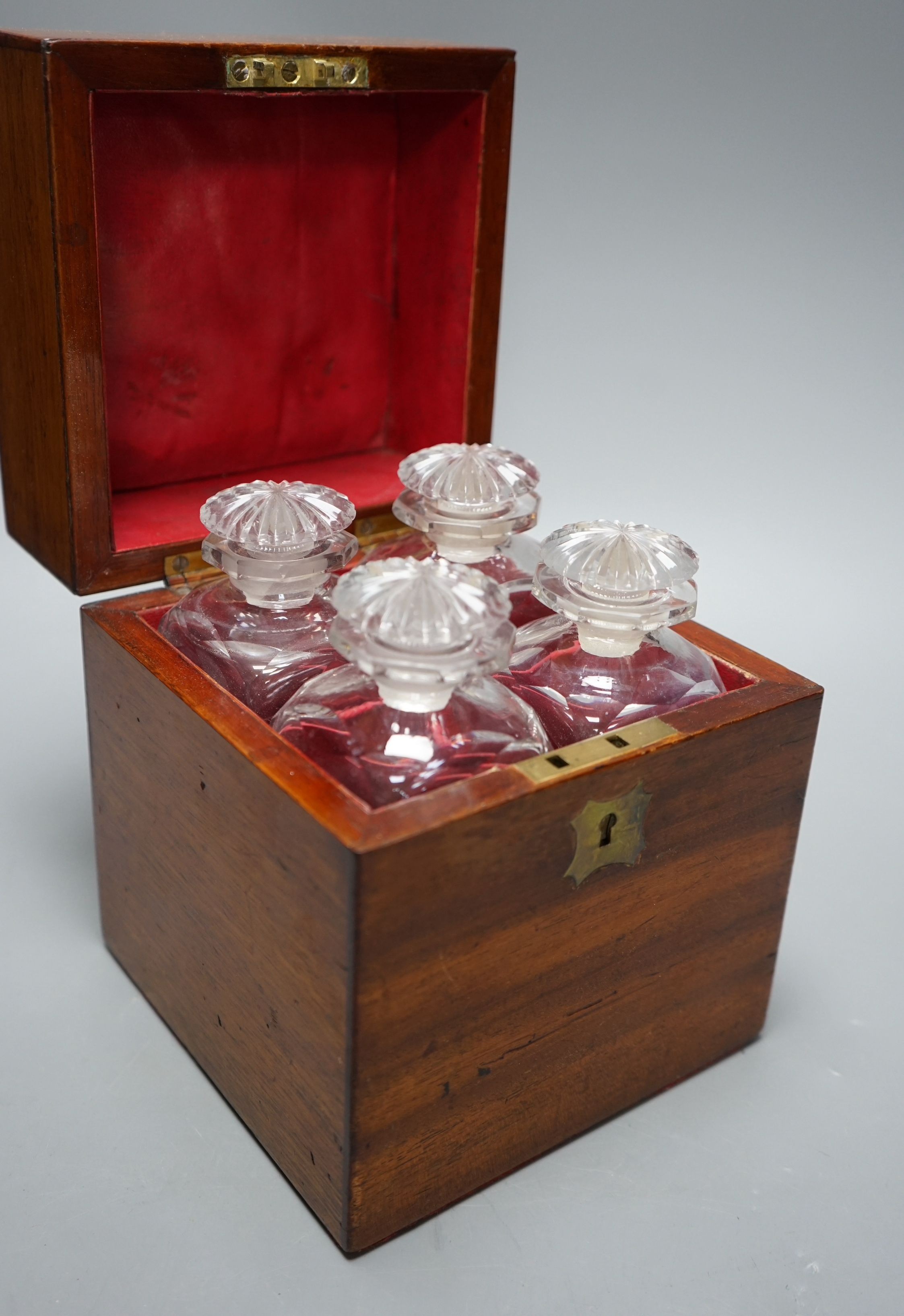 A late Georgian mahogany cased set of four cut glass liqueur decanters, 20cm high x 16.5cms wide